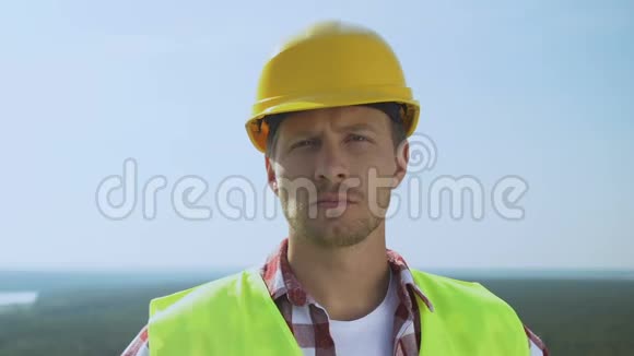 有经验的男建筑工人戴着安全帽看相机提供优质服务视频的预览图