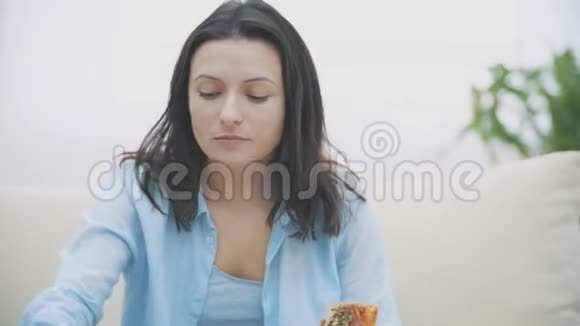 慢点一个可爱的女人她在看电视嚼披萨好吃好吃4K视频的预览图