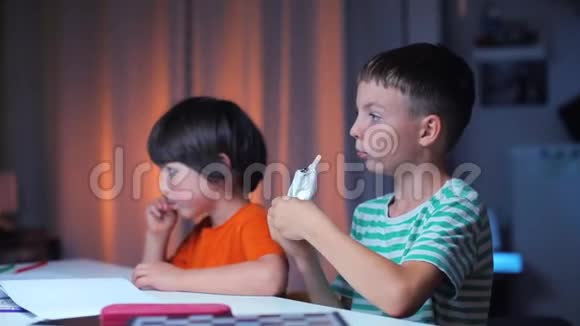 两个快乐的男孩坐在桌子旁吃冰淇淋的画像视频的预览图