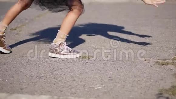 特写镜头十几岁的女孩腿穿着粉红色闪亮的运动鞋女孩正在做体操一个手推车视频的预览图