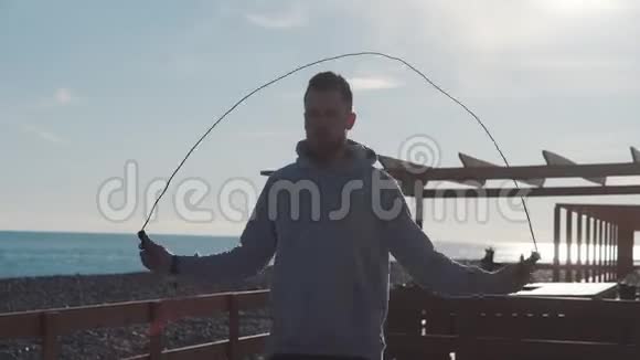 海上沙滩上的跳绳男剪影视频的预览图