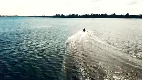 喷气式滑雪板以速度穿过波浪在阳光明媚的天气里在河上滑雪无人机射击视频的预览图
