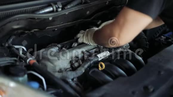 男性汽车修理工在汽车发动机上更换火花塞视频的预览图