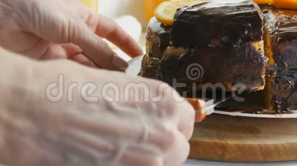 女性手拿一大块海绵蛋糕上面有橘子片和巧克力糖霜甜糖尿病食物视频的预览图