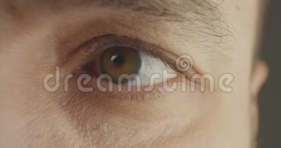 美丽的眨眼男性棕色眼睛特写雄性棕色眼睛打开人类虹膜宏观自然美电影4k视频的预览图