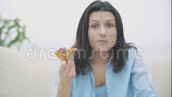 慢点亲密的可爱的女人谁正在咀嚼一块比萨饼和变化的情绪好吃好吃4K视频的预览图
