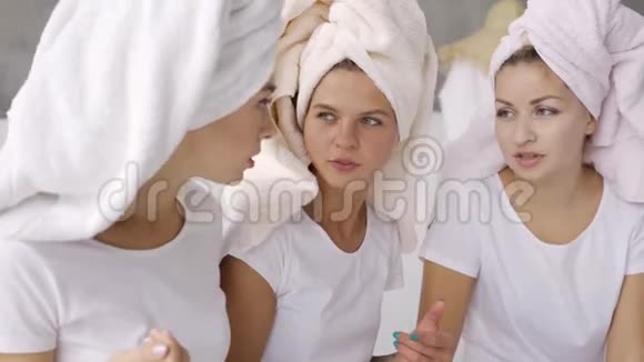 肖像三个可爱的女朋友穿着白色t恤头上有毛巾在家里在浴室里聊天母鸡党视频的预览图