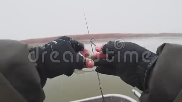 垂钓者准备硅胶鱼饵鱼钩和铅鱼以便在河上钓鱼视频的预览图