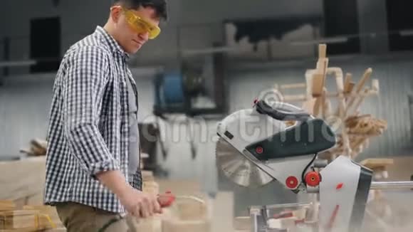 护目镜中的工作人员使用空气压缩机从圆锯中吹锯末视频的预览图