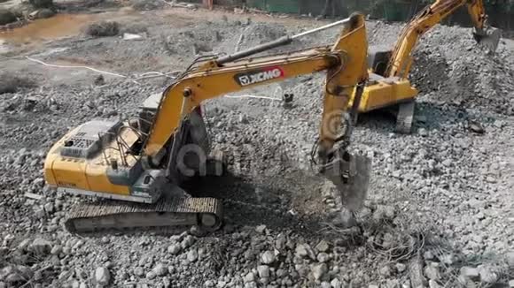 高空在两台挖掘机的作用下围绕着一个拆除场地的视野移动视频的预览图