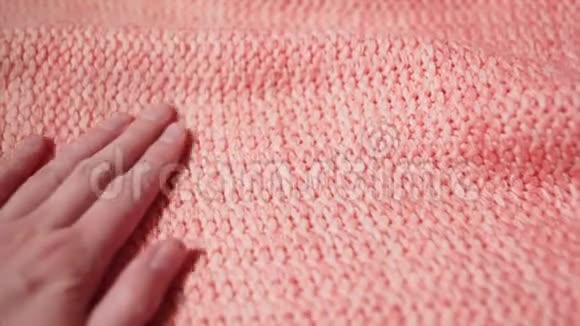女孩手触摸一件柔软温暖的丙烯酸或珊瑚色或粉红色的羊毛毛衣视频的预览图