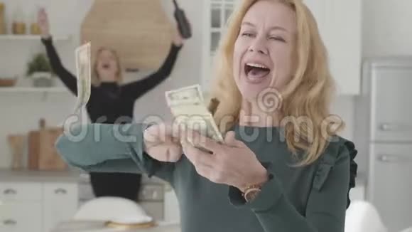 富有积极成熟的高加索女人带着雪茄的钱和微笑她的女朋友喝着酒视频的预览图