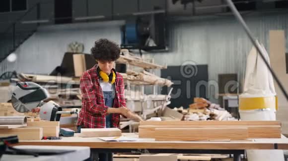 木材车间工人在工作场所用磨料块抛光木材视频的预览图