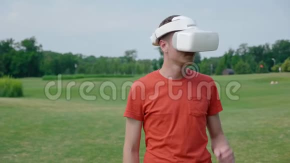 一个男人在公园里用VR耳机抓脖子视频的预览图