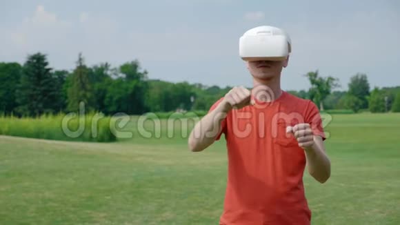 一名男子使用VR耳机在公园的虚拟游戏中驾驶汽车视频的预览图