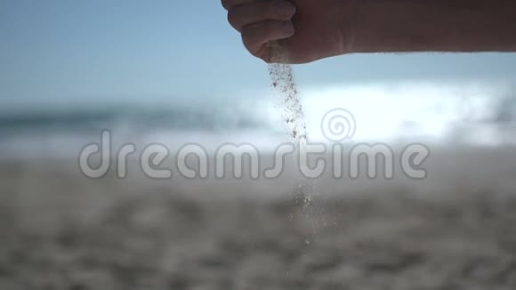 在海滩上近距离用近人的手射击拿着沙滩沙慢慢地打开视频的预览图