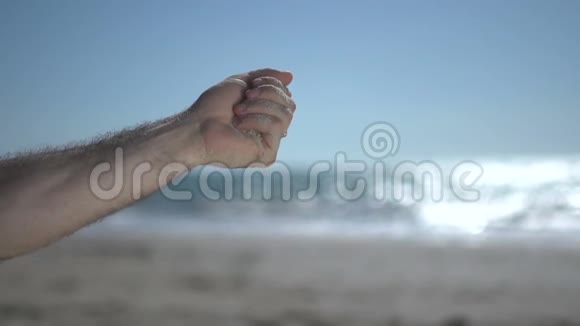 在海滩上近距离用近人的手射击拿着沙滩沙慢慢地打开视频的预览图