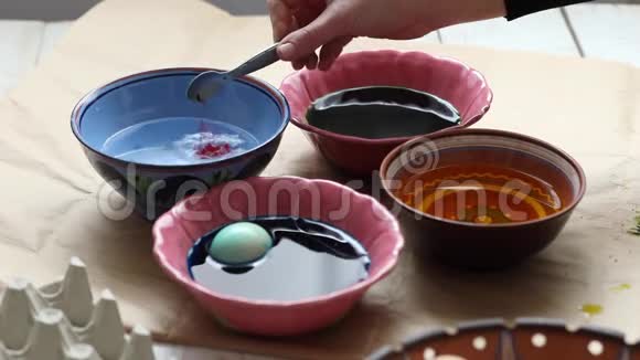 准备复活节女人在家里的餐桌上染复活节彩蛋视频的预览图