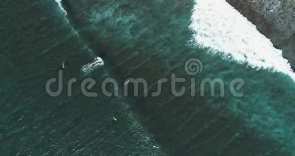 自上而下的空中跟踪拍摄技术娴熟的男性冲浪者在晴朗的蓝色天气里乘着巨浪在海上捕捉海浪视频的预览图