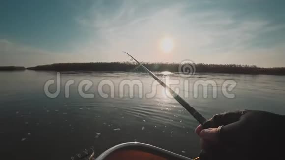 日落时分垂钓者从河上的一条船上旋转捕食鱼视频的预览图