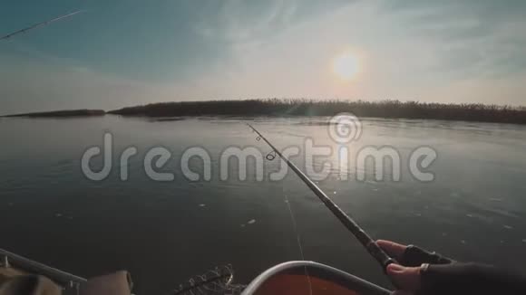 日出时渔夫从河上的一艘船上纺捕食鱼视频的预览图