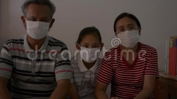 一个亚洲家庭在检疫中戴防护面罩以防止冠状病毒的肖像视频的预览图