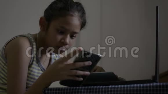 亚洲可爱的女孩穿着单身衬衫在网上看课在床上做作业女青少年在家学习视频的预览图