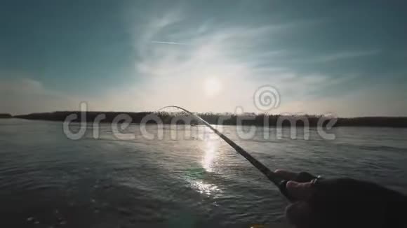 日落时分渔夫从河上的一艘船上旋转捕食的鱼视频的预览图