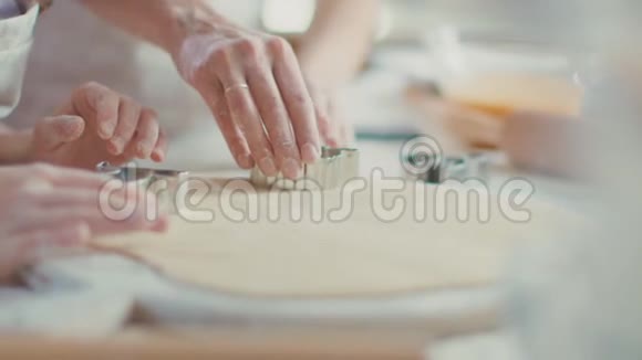 把女人和女孩用切饼机在餐桌上切面团视频的预览图