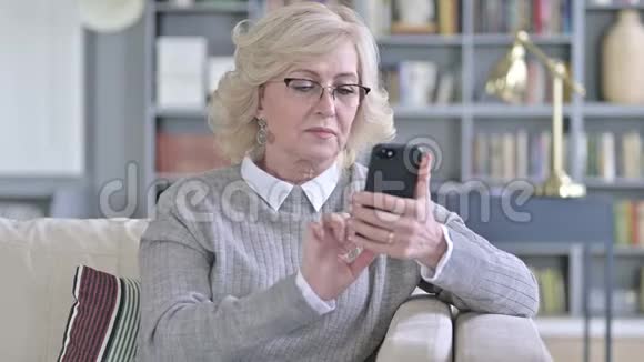 快乐的老妇人在智能手机上做视频聊天视频的预览图