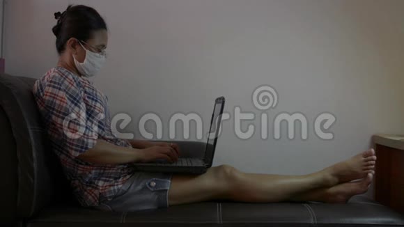 在隔离期间戴防护面罩在家工作的亚洲妇女女商人穿着便装手提电脑视频的预览图