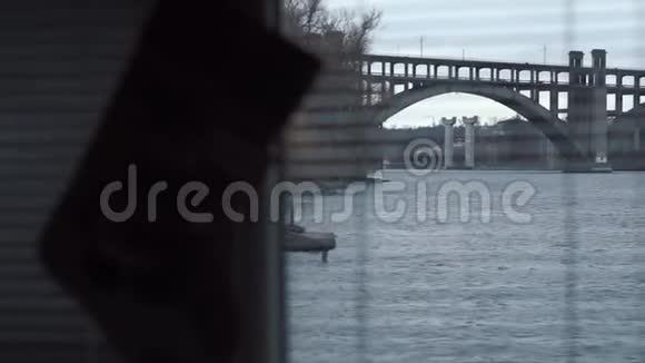 从一个房子一个房间一扇窗户通过打开的百叶窗河流一座桥一座城市汽车一个窗户视频的预览图