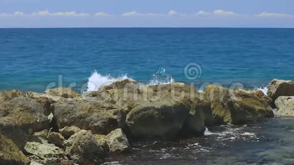 慢动作美丽的波浪景观在石头上刹车大西洋绿松石水和蓝天背景上的大岩石W视频的预览图