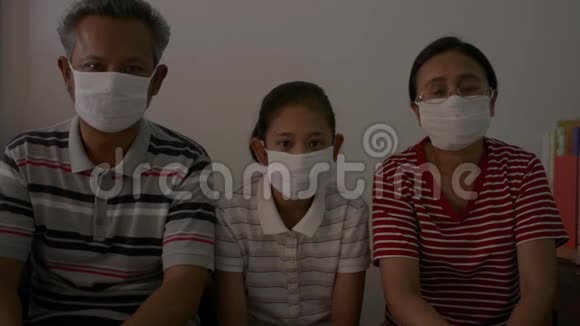 一个亚洲家庭在检疫中戴防护面罩以防止冠状病毒的肖像视频的预览图