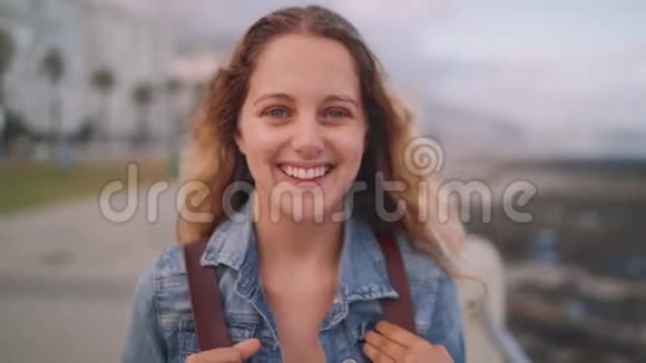城市街道上一位年轻迷人的微笑女人的肖像感到快乐看着镜头视频的预览图