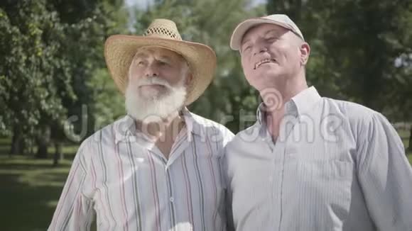 两个老人把目光移开邀请第三个朋友加入公园户外休闲成熟的人视频的预览图
