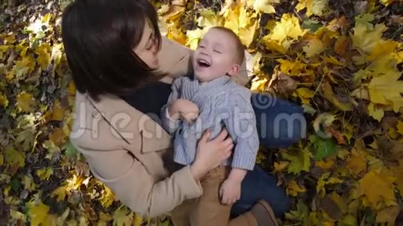 快乐的妈妈在公园逗笑的蹒跚学步的儿子视频的预览图