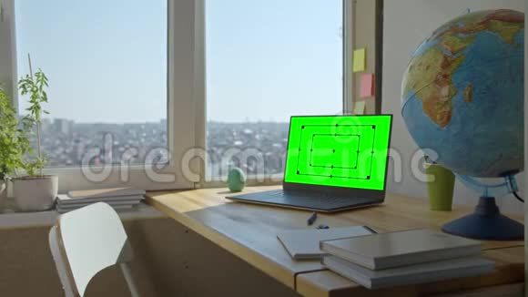 绿色屏幕模拟木制桌子上的笔记本电脑视频的预览图