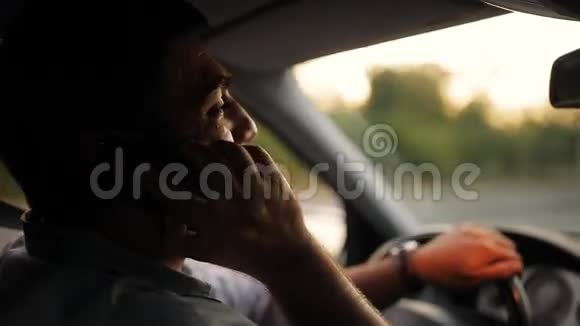 英俊的年轻人在开车时用手机说话冒险鲁莽司机的坏习惯交通安全视频的预览图
