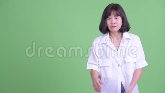 一个穿着衣服的亚洲女商人一边向后面炫耀一边说话视频的预览图