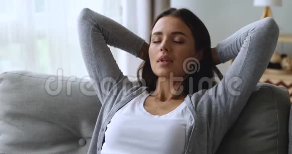 美丽迷人的年轻女子躺在沙发上深呼吸视频的预览图