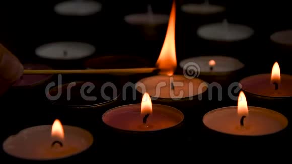 在黑色背景下点燃的茶光蜡烛的特写组合在一起浪漫气氛视频的预览图