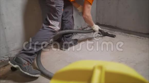使用吸尘器的工人清除建筑碎片一名工人正在打扫工业场所公寓视频的预览图