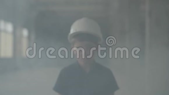 一个戴着防护头盔的男孩从烟柱中出来看着摄像机的照片火的概念视频的预览图