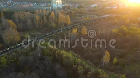 鸟瞰秋季在乡村场景下火车火车在日出时穿过农村火车视频的预览图