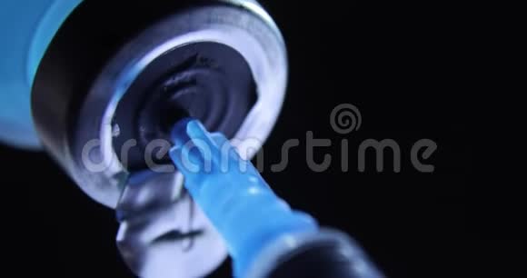 将蓝色冠状病毒疫苗接种到黑色背景下的注射器中视频的预览图