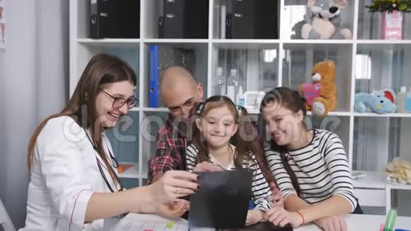 父亲带着两个女儿参加了医生办公室治疗师的招待会带着微笑考虑x光视频的预览图