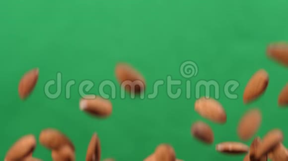 杏仁在绿色背景上上下飞行用杏仁煮健康的食物视频的预览图