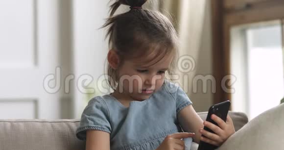 可爱的聪明女孩独自一个人拿着智能手机视频的预览图
