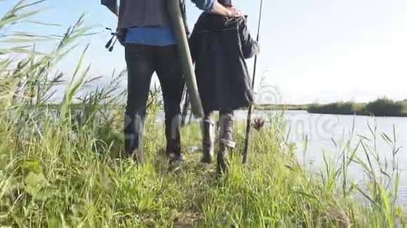 父亲和儿子在湖边散步他们带着狗和铲视频的预览图